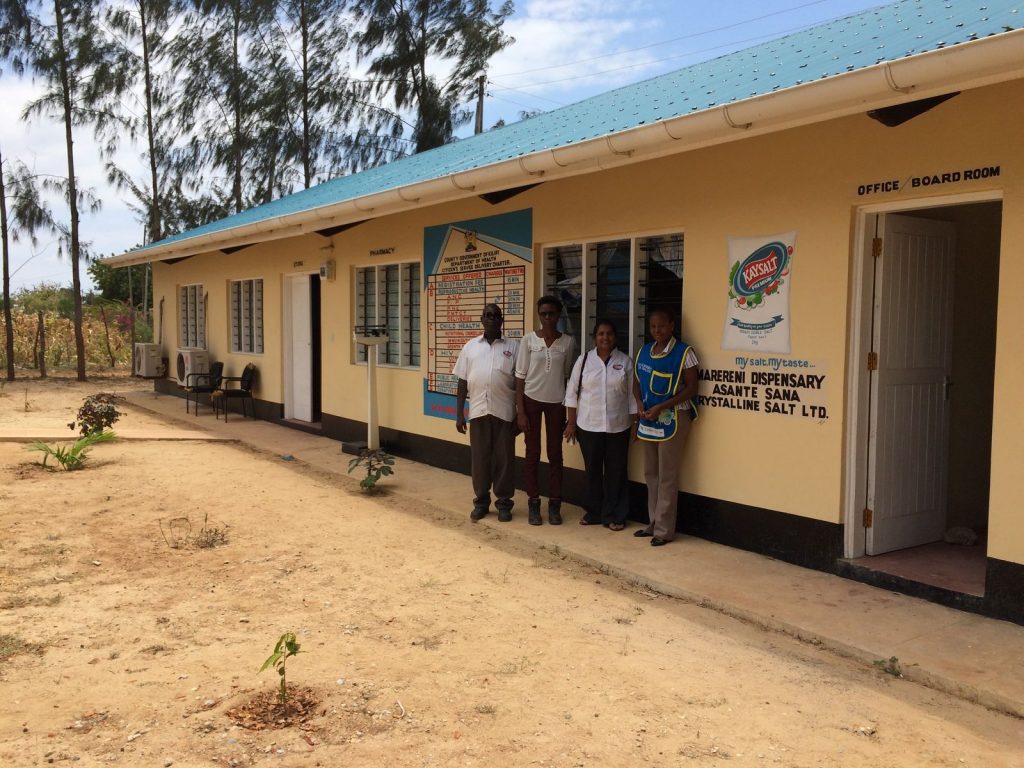 Krystalline Salt staff and Chief Clinical Officer outside Marereni Dispensary with Kaysalt Premium logo